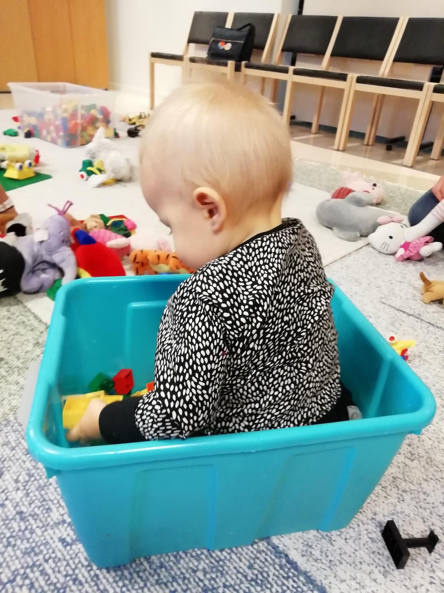 Vauva leikkii muovisessa lelulaatikossa