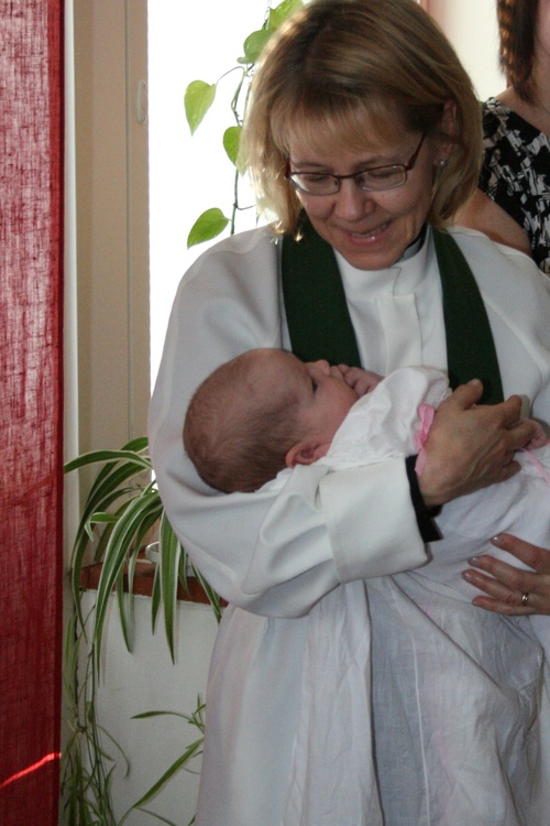 Pastori Eija Tujula ja juuri kastettu tyttövauva.