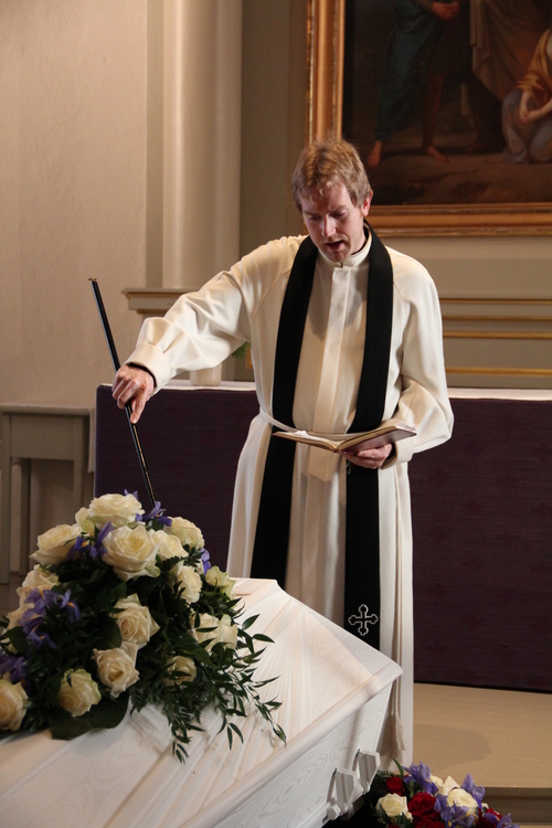 Pastori Tarmo Halttunen siunaa vainajaa Pyhän Laurin kirkossa.