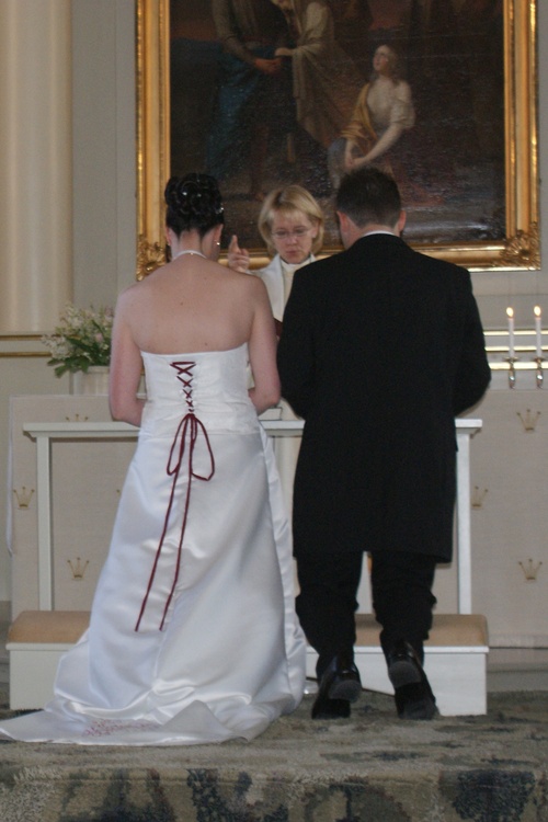 Pastori Eija Tujula vihkiparin kanssa Pyhän Laurin kirkossa.