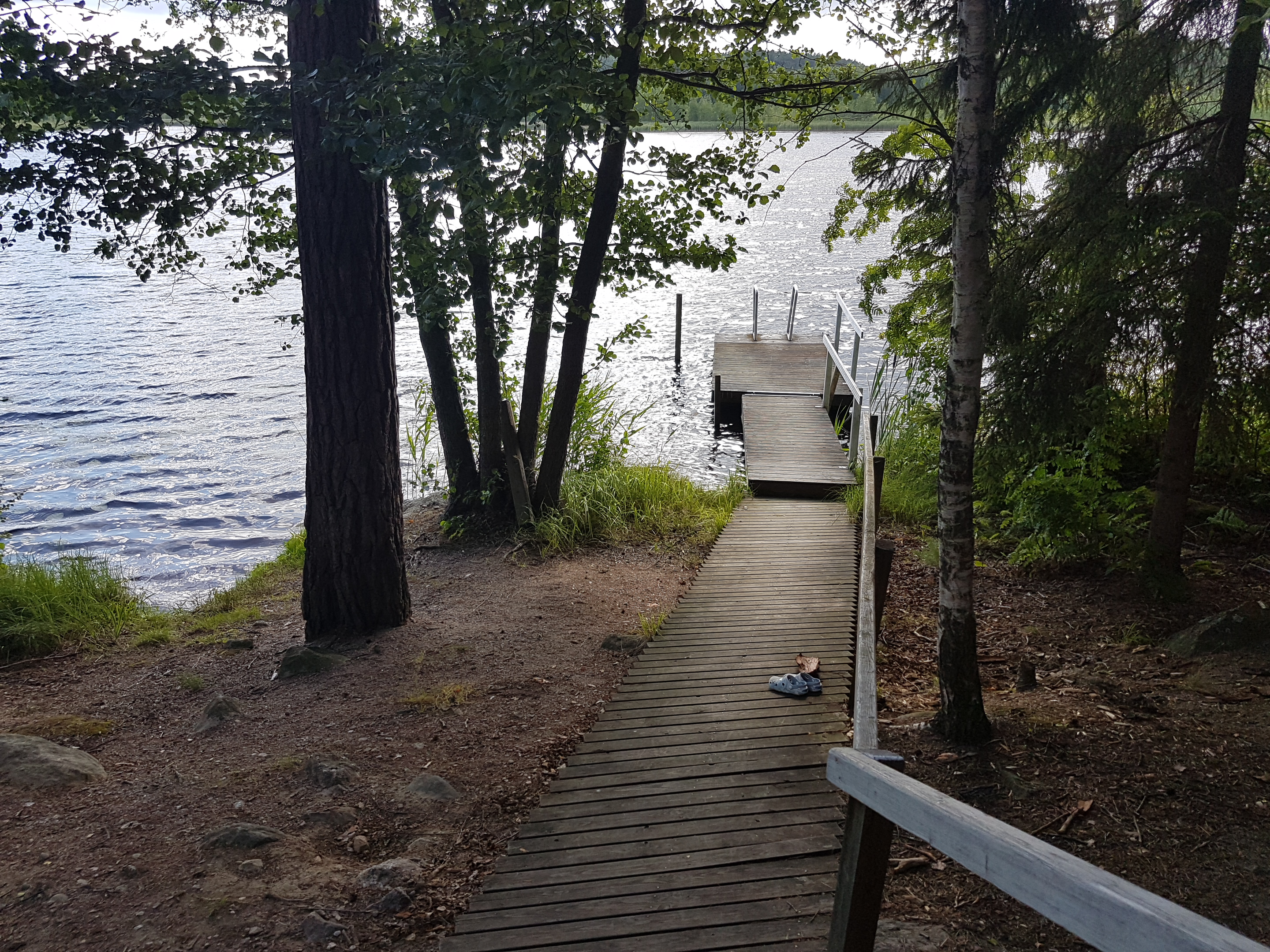 Poukapirtin laituri ja sinisenä kiiltävä Alasjärvi.