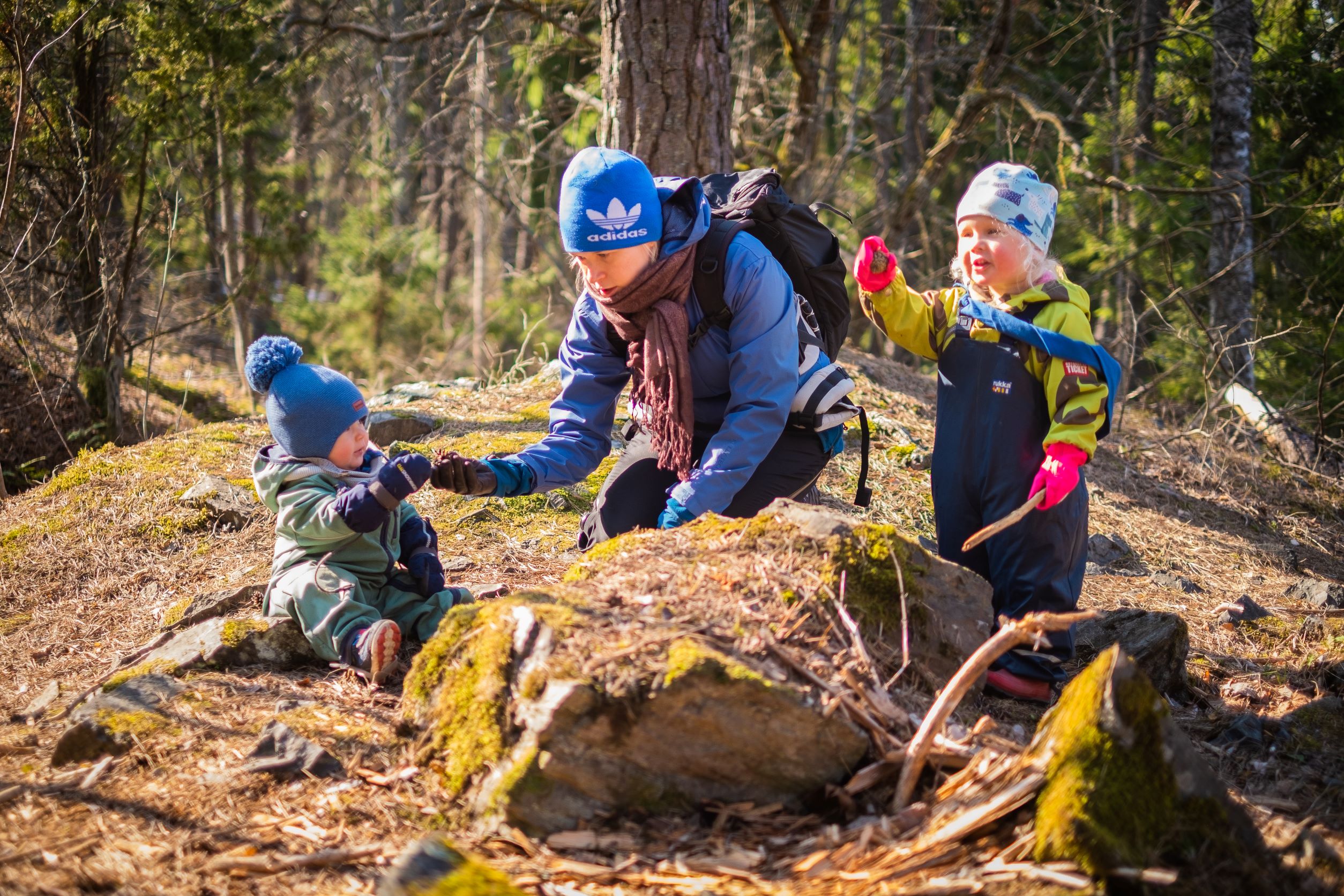 Nainen ja kaksi lasta metsässä